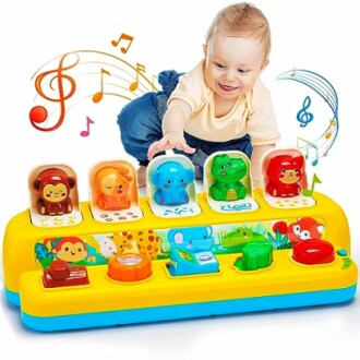 Baby playing with a colorful musical toy featuring animals and musical notes.