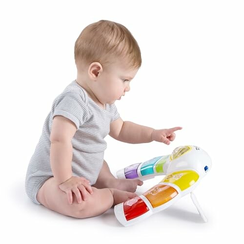 Baby sitting and playing with colorful musical toy