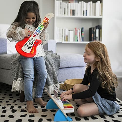 Children playing with toy guitar and keyboard indoors.