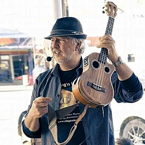 Man holding a ukulele and wearing a hat